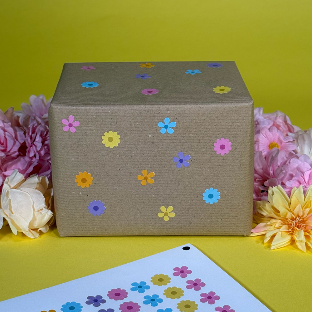 Picture showing a box wrapped in brown paper, decorated with pastel coloured flower stickers