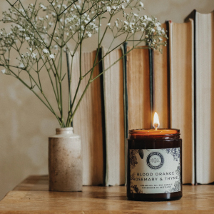 Candle on a bookshelf. An image showing textured labels stuck onto a brown jar. Image cortosey of Scotts Apothecary