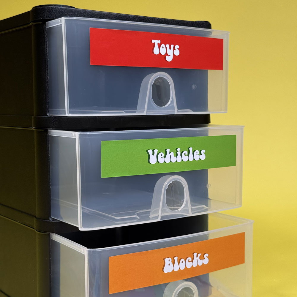 Picture showing labels on a small plastic unit with 3 drawers for toys