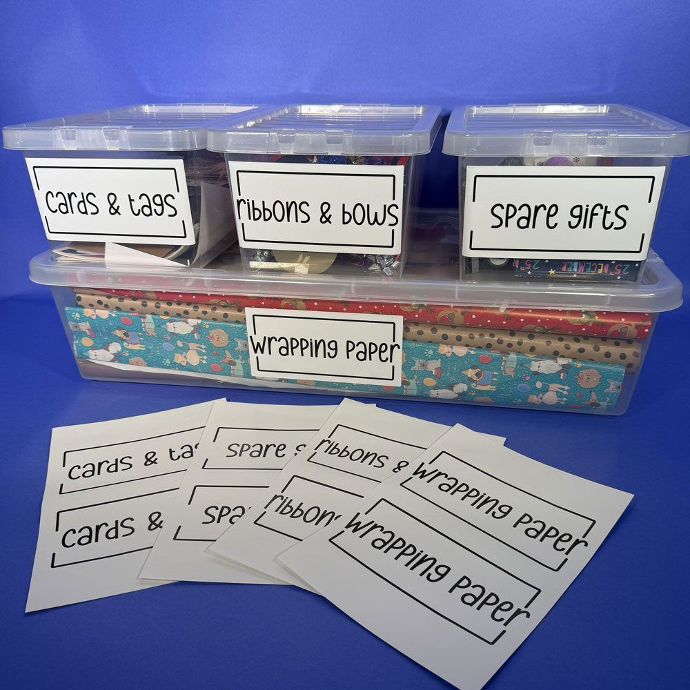 Picture showing large, clear storage boxes labelled with items that are needed for giftwrapping